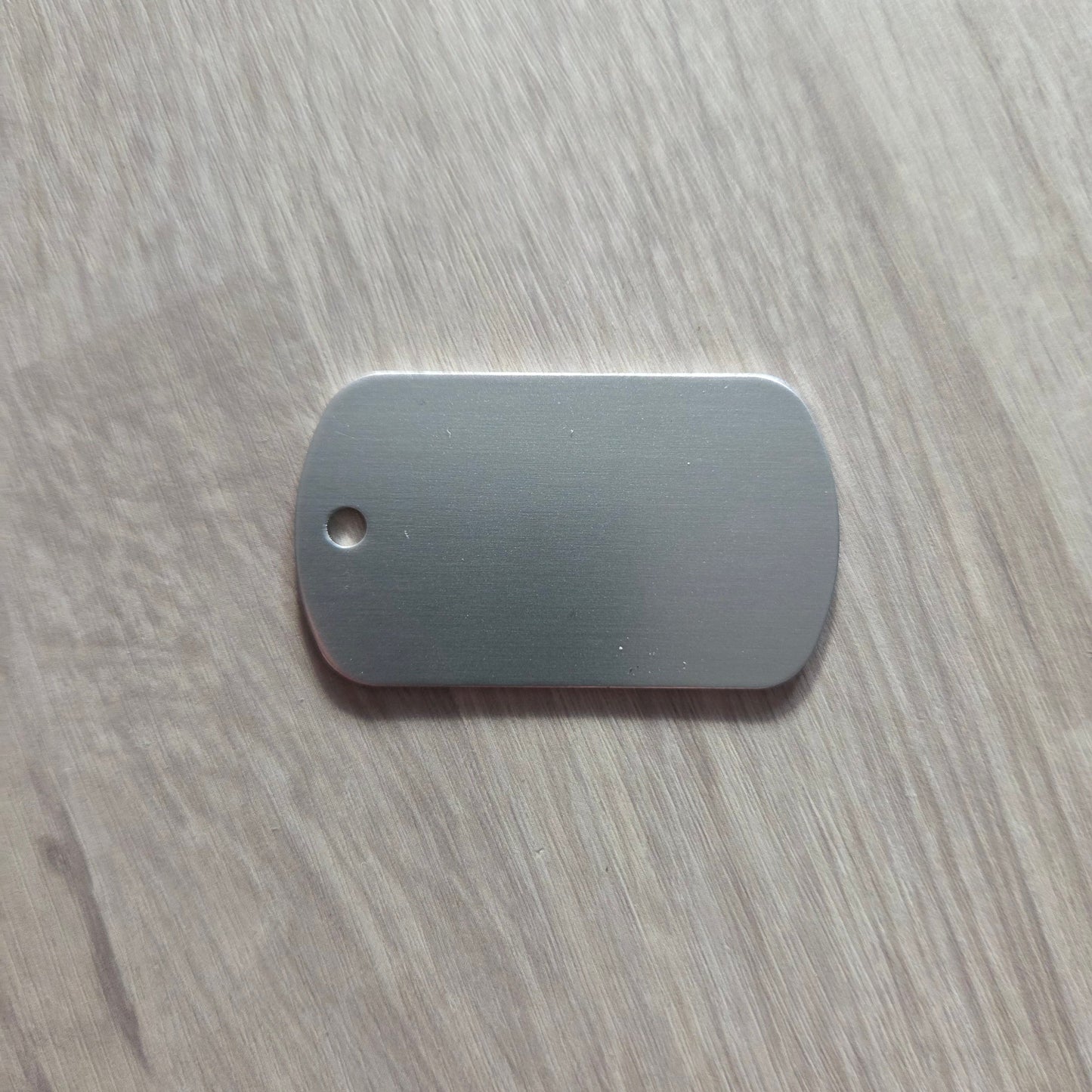 Metallic dog tag on a wooden surface