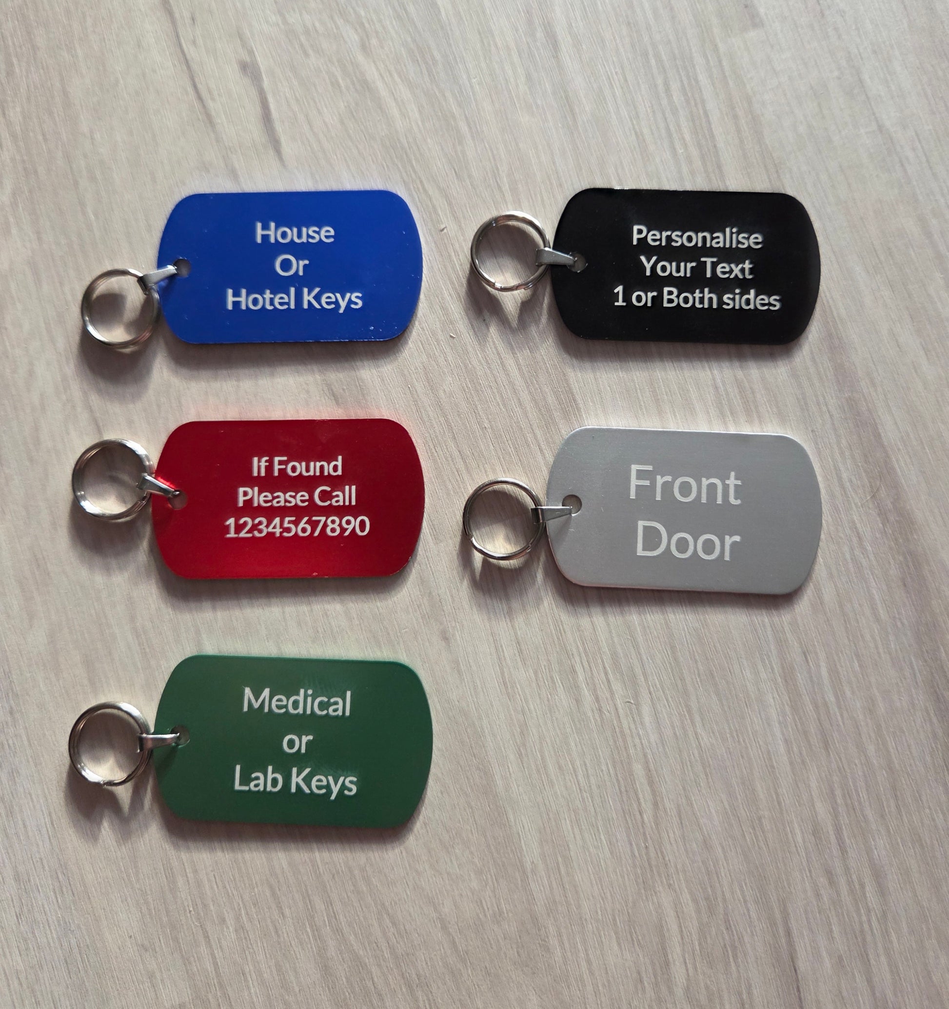 Set of five key tags in different colors with text on a wooden surface
